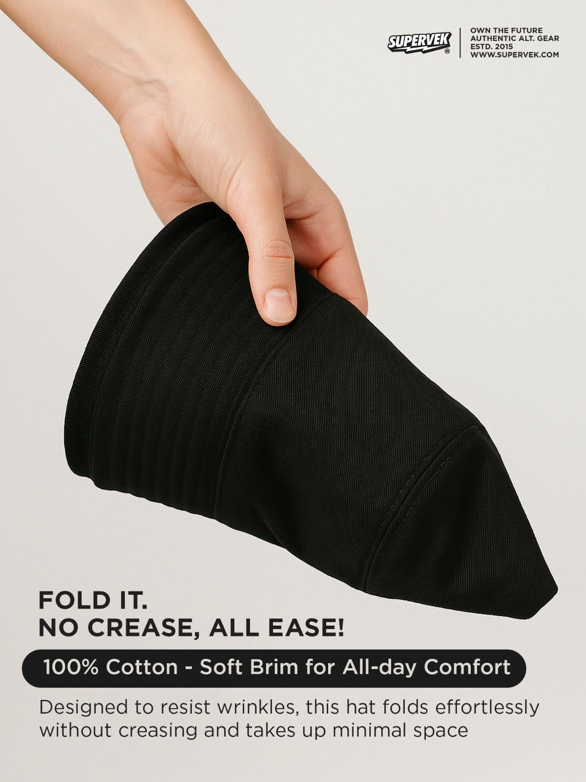 Black fedora hat being held by a hand against a plain background.